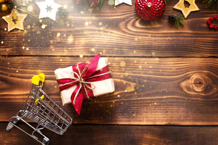 Christmas flat lay on the theme of shopping, buying gifts for the new year. Black Friday, sale, decor of stars, spruce branches, ball, beads, garlands, cones on a wooden background. Space for textの写真素材
