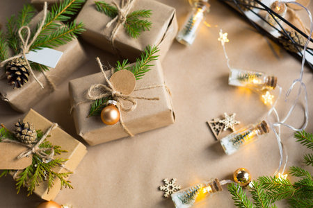 Pack a gift for Christmas and new year in eco-friendly materials: kraft paper, live fir branches,...