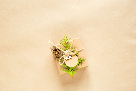 Gift box for Christmas and new year in eco-friendly materials: kraft paper, live fir branches, cones, twine. Tags with mock up, natural decor, hand made, DIY. Flatly, background, frame, Minimalismの写真素材