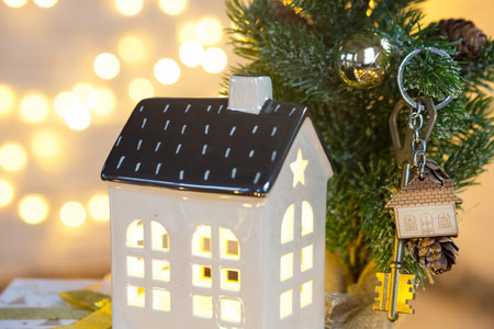 Key to the house with a keychain on a table with a Christmas decor. A gift for New Year, Christmas....