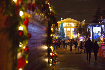People walk at the Christmas market in the festive decor of the streets near Dramatic theater. Exhibition and shopping malls in the city center. New Year. Kaluga, Russia, December 2020, editorial.のeditorial素材