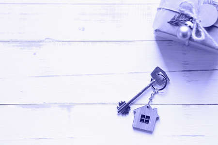 The key to the house on a natural background with a box with a gift for Christmas and new year. Eco-friendly housing, mortgage, loan, booking, purchase of real estate, moving into your homeの写真素材