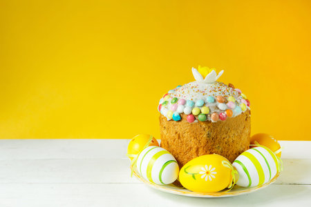 Easter cake with painted eggs on a platter in a white table. traditional festive food. yellow...