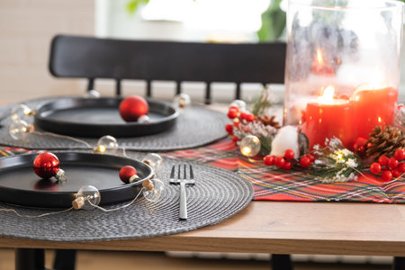 Festive table set in the living room for Christmas and New year in loft style. Christmas tree, black...
