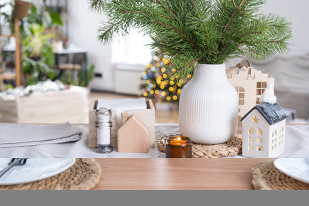 Festive Christmas decor in white kitchen, festive breakfast, white scandi interior. The figure of a cozy house ion set table. New Year, mood, cozy home. copy spaceの写真素材