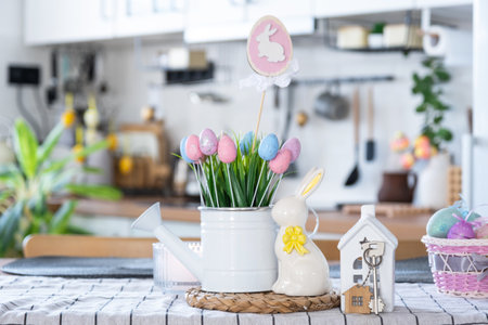 Key to house of cozy home with Easter decor with rabbit and eggs on table of kitchen. Building, design, project, moving to new house, mortgage, insurance, rent and purchase real estateの写真素材