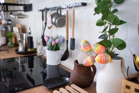 Interior of kitchen and details of decor of utensils with Easter decoration of colorful eggs in a loft style. Festive interior of a country houseの写真素材