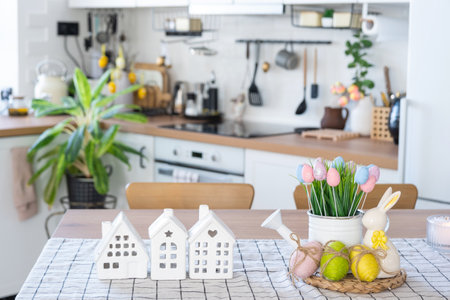 Key to house of cozy home with Easter decor with rabbit and eggs on table of kitchen. Building, design, project, moving to new house, mortgage, insurance, rent and purchase real estateの写真素材
