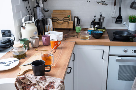 A mess in the kitchen, dirty dishes on the table, scattered things, unsanitary conditions. The dishwasher is full, the kitchen is untidy, everyday lifeの写真素材