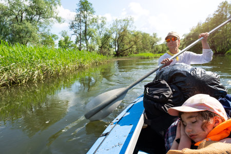 Family kayak trip. Father and daughter rowing boat on the river, a water hike, a summer adventure. Eco-friendly and extreme tourism, active and healthy lifestyleの写真素材