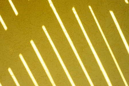Yellow texture of the wall with a bark beetle pattern and light stripes. summer bright sunny...