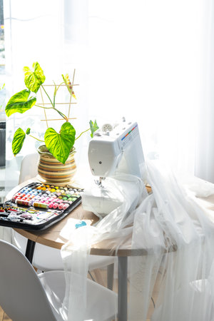 Sewing layout with multicolored spools of thread close-up, needles, electric sewing machine. Filling the thread into the sewing needle, adjusting the tension. hobby, home businessの写真素材