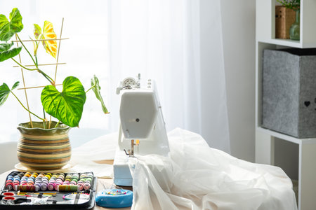 Sewing layout with multicolored spools of thread close-up, needles, electric sewing machine. Filling the thread into the sewing needle, adjusting the tension. hobby, home businessの写真素材