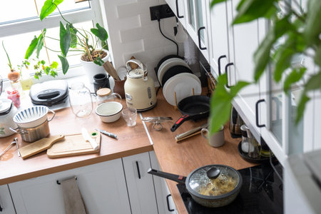 A mess in the kitchen, dirty dishes on the table, scattered things, unsanitary conditions. kitchen is untidy, everyday lifeの写真素材