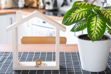 Key to house of cozy home on table of kitchen. Building, design, project, moving to new house, mortgage, insurance, rent and purchase real estateの写真素材