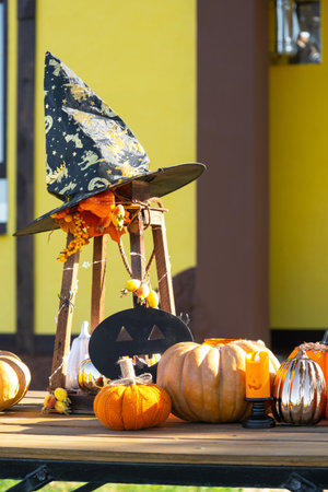 Autumn decor on the porch of the house outside in the yard of pumpkin, lantern, garlands, hats, jack lantern. Halloween party, autumn mood, Harvest festivalの写真素材