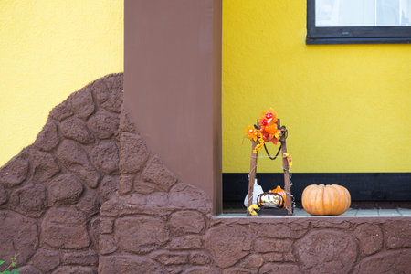 Autumn decor on the porch of the house outside in the yard of pumpkin, lantern, garlands, hats, jack lantern. Halloween party, autumn mood, Harvest festivalの写真素材