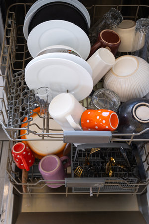 A lot of dirty dishes in the dishwasher. Helping the hostess, economy and ecology. Cleaning in the kitchenの写真素材