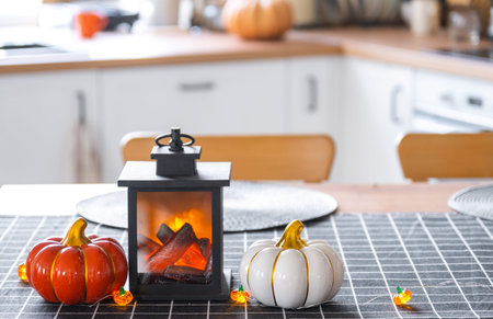 Decor of white classic kitchen with pumpkins, garlands, latern for Halloween and harvest with figurine of house. Autumn mood in home interior, modern loft style. real estate, insurance, mortgageの写真素材