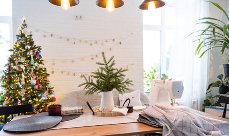 Sewing process on a sewing machine, a needle with a thread and a holder close-up stitch the white checkered fabric. Preparation for Christmas and new year, textiles for cozy in festive decor interiorの写真素材