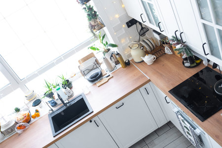 Christmas decor in white kitchen, festive mess, village interior with a snowy Christmas tree and...