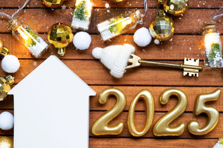 House key with tiny figure of home mock up on festive brown wooden background, lights of garlands....