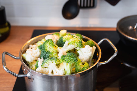 Broccoli and cauliflower are steamed in a saucepan - healthy diet, baby food, cooking in a steamerの写真素材