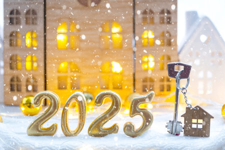 Golden figures number 2025 and tiny home on background of cozy windows of a house with warm light with festive decor of stars, snow and garlands. Greeting card, Happy New Year, cozy homeの写真素材