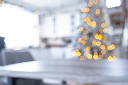 Blurred Gray Wooden empty table to demonstrate product with space for text in white kitchen, modern interior with Christmas tree and fairy lights. New Year, Christmas mood, cozy home.の写真素材