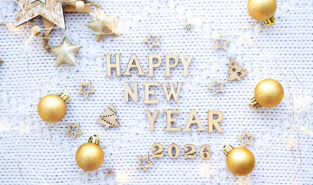 Happy New Year wooden numbers 2026 on cozy festive white knitted background with sequins, stars, lights of garlandsの写真素材
