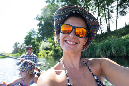 Man and woman couple, child 8 years old, selfies are happy in family kayak trip rowing boat on the river, water hike, a summer adventure. Eco-friendly tourism, active and healthy lifestyleの写真素材