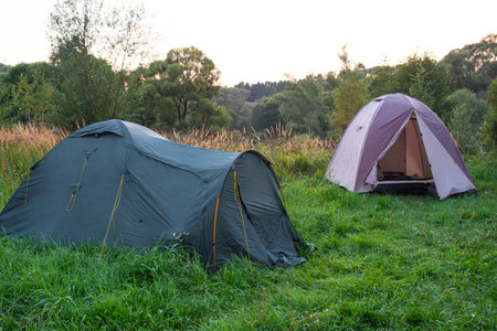 Installed tourist tent in a camping in nature in the forest. Domestic tourism, active summer holidays, family adventures. Ecotourism, sport, hike. Copy space, mock upの写真素材