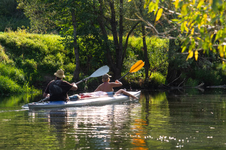 Kayak trip for an adult couple rowing boat on the river In the bright sunlight, a water hike, a summer adventure.の写真素材