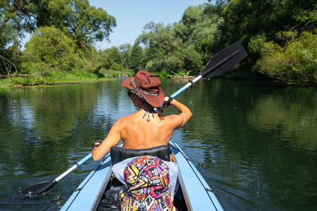 Family kayak trip. Mom and daughter rowing a boat on the river, a water hike, a summer adventure. Eco-friendly tourism, active and healthy lifestyleの写真素材