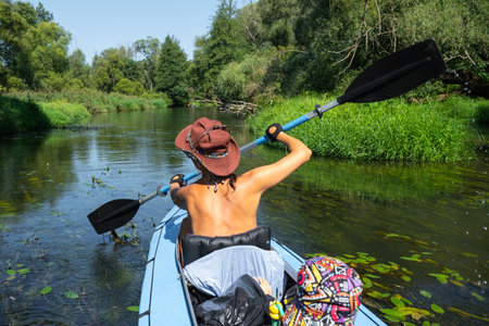 Family kayak trip. Mom and daughter rowing a boat on the river, a water hike, a summer adventure. Eco-friendly tourism, active and healthy lifestyleの写真素材