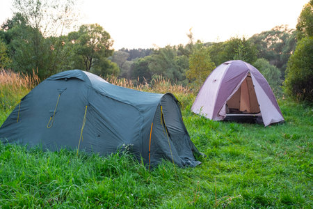 Installed tourist tent in a camping in nature in the forest. Domestic tourism, active summer holidays, family adventures. Ecotourism, sport, hike. Copy space, mock upの写真素材