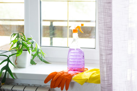Window cleaning products are lying on the windowsill with a rag, spray, detergent. Spring cleaning...