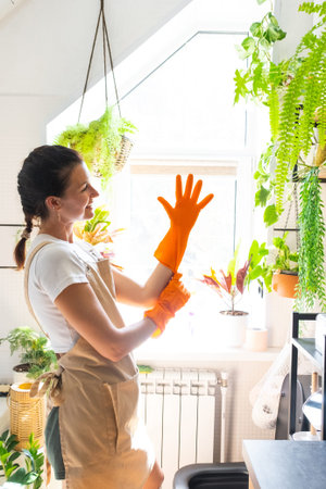 Portrait Woman in rubber gloves and apron manually cleaning in bathroom with rag cleaner and mop...