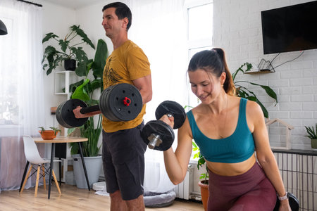 Woman and man in a sports uniform is engaged in fitness and strength training with a barbell and...