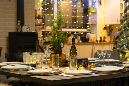 Festive interior of house is decorated for Christmas and New Year in loft style with black stove, fireplace, Christmas tree. Warm studio room with set table, burning wood, cozy and heating of homeの写真素材