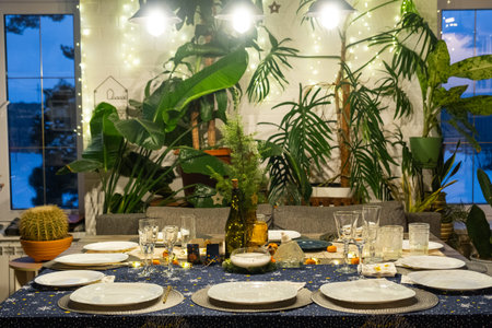 A festive table set for guests for Christmas and New Year, in the living room, plates, bottles,...