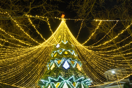 High city Christmas tree with a mushroom cap made of garlands, glows at night on the street. Christmas, New Year, decoration of the city.の写真素材
