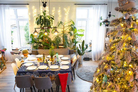 A festive table set for guests for Christmas and New Year, a Christmas tree in the living room,...