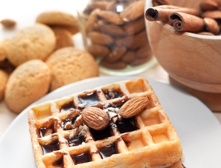 Mortar with walnuts, cinnamon and wafer with chocolate sauce on the wood backgroundの写真素材