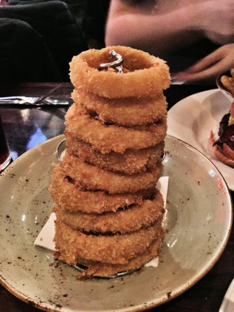 Fried breaded onion rings on a plate in a restaurant.の写真素材