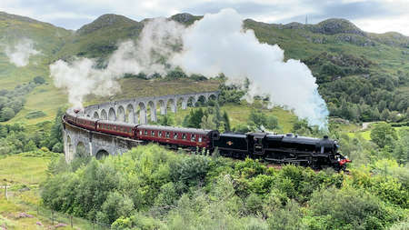 A view of the Glenfinnan Viaduct with a steam train going overの写真素材