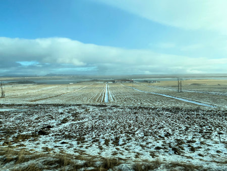 Icelandic winter landscape with snow covered hills and blue cloudy skyの写真素材