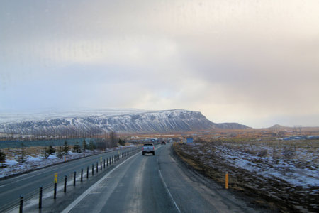 Icelandic landscape with snow-covered mountains and road in winterの写真素材