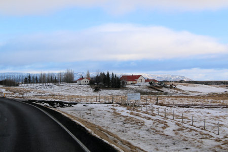 Icelandic landscape with snow-covered mountains and road in winterの写真素材