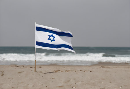 Israel flag waving on the beach in front of a stormy skyの素材